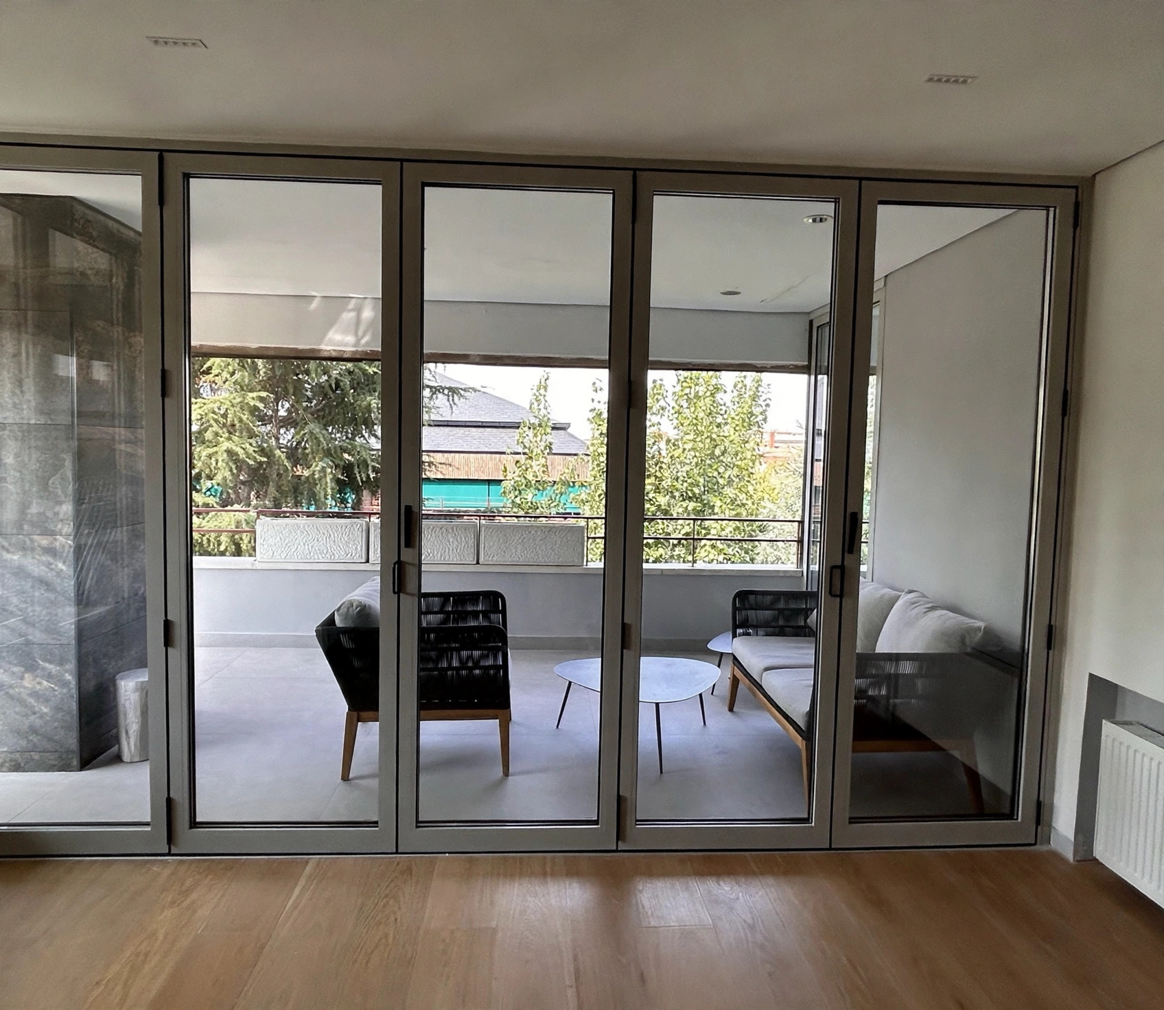 Terraza amueblada con zona de estar exterior y grandes ventanales