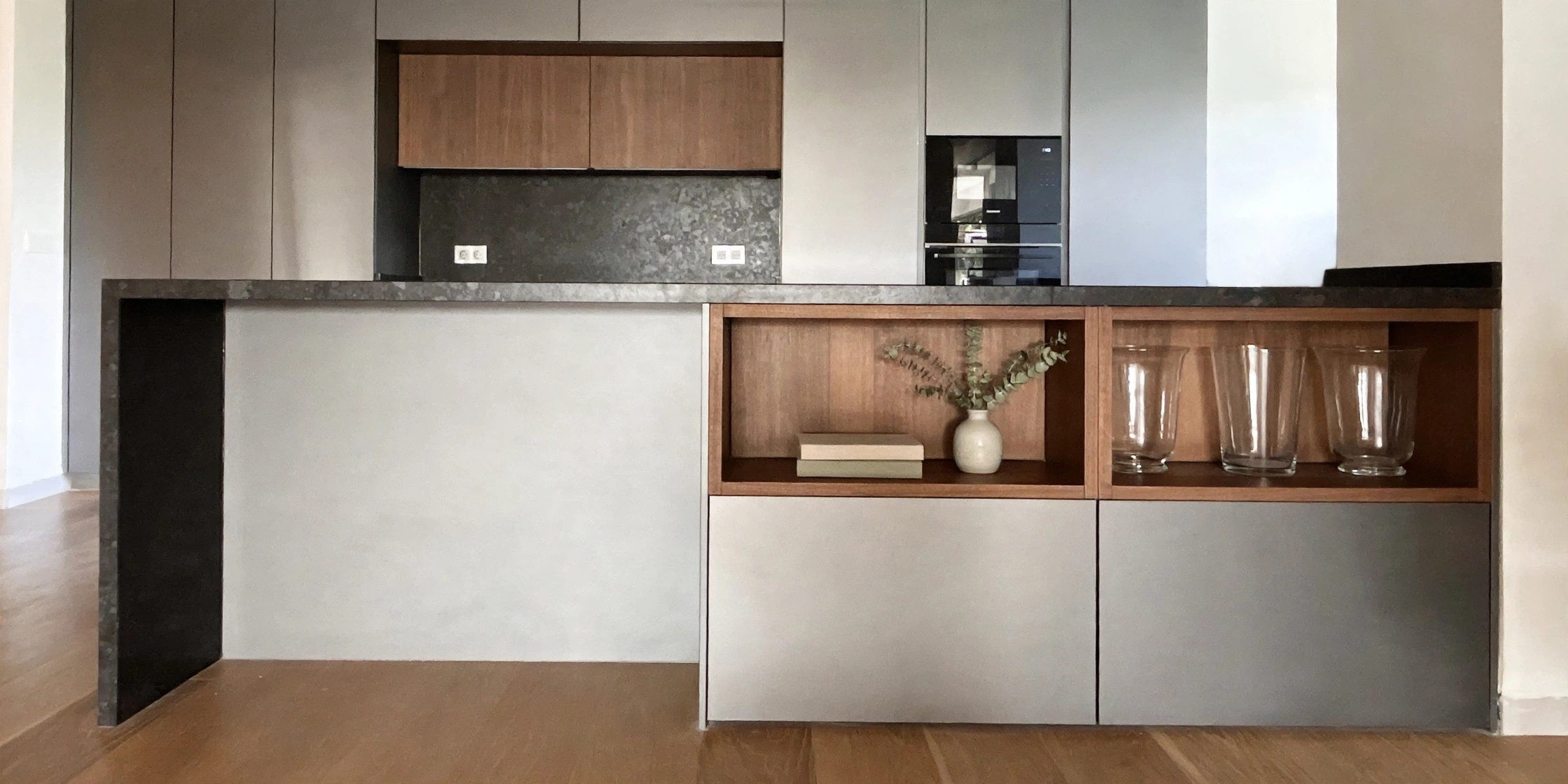Cocina abierta con frente de madera, isla oscura y encimera continua