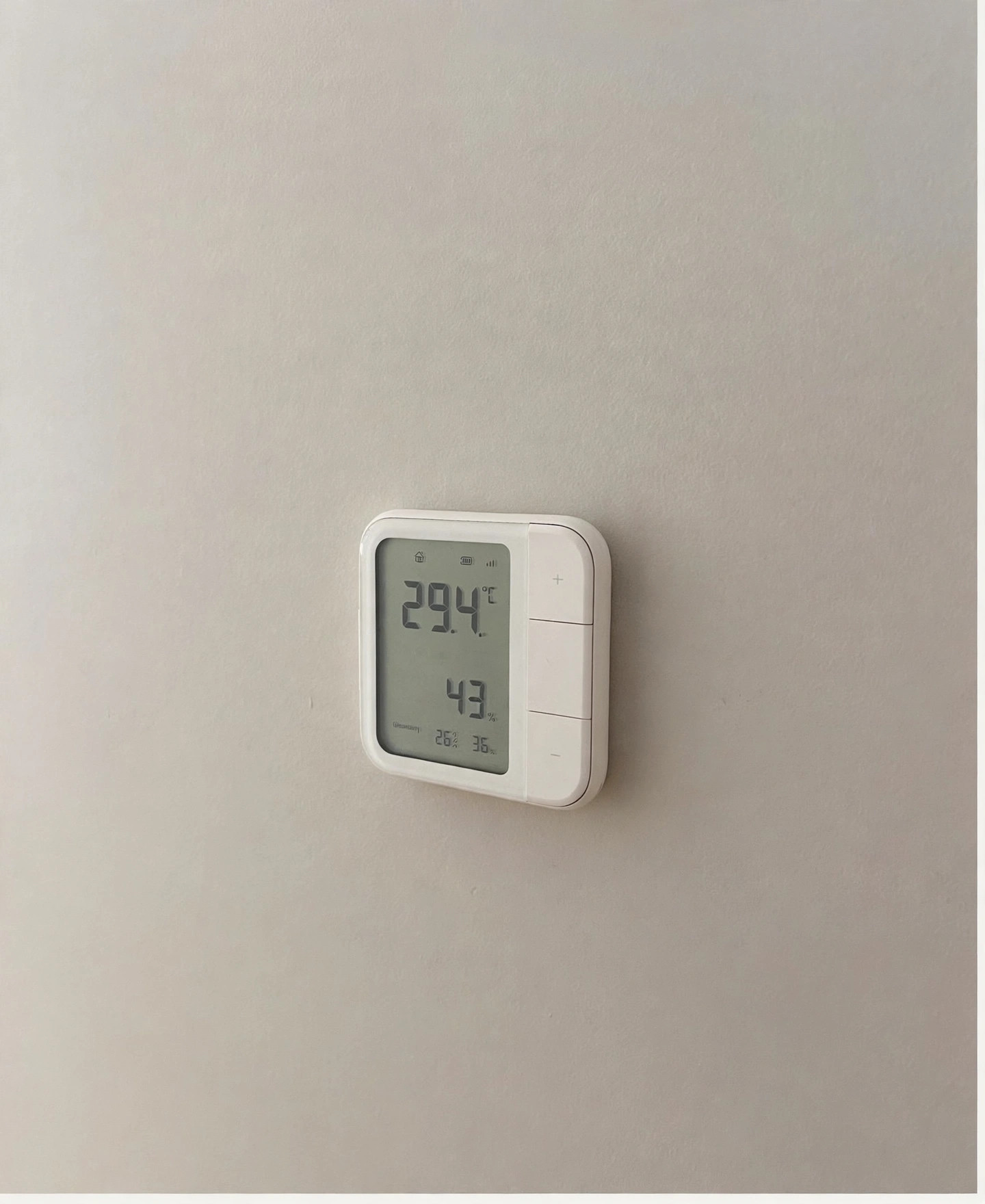 Termostato digital instalado sobre una pared en tono neutro