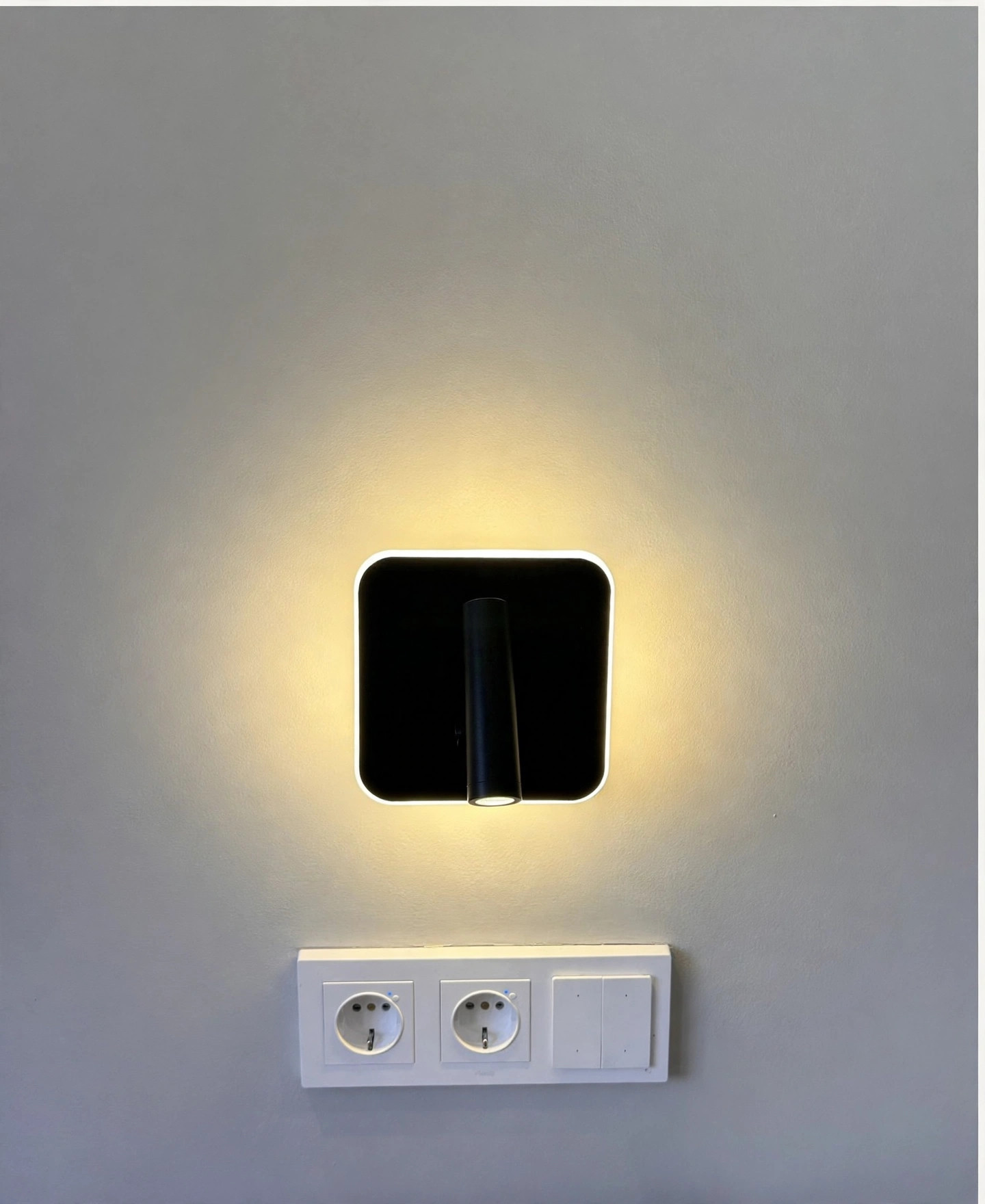 Aplique negro encendido con luz ambiental cálida